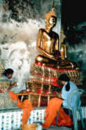 2 Frauen restaurieren eine Buddha Statue